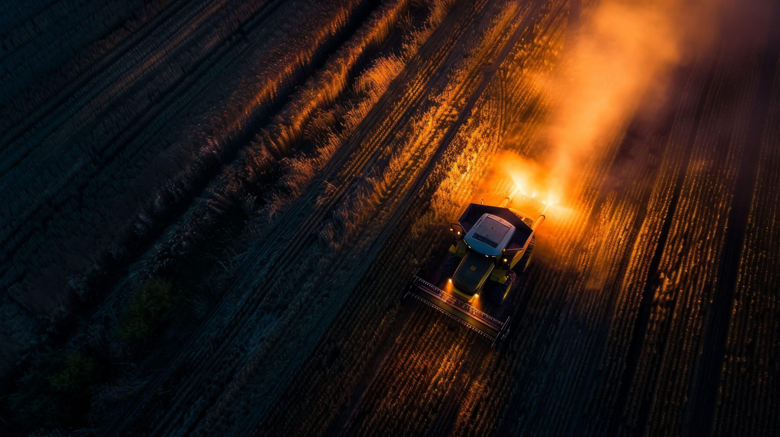 Eine Landmaschine in Aktion, deren Beleuchtung perfekt die Fahrzeugdimensionen sichtbar macht