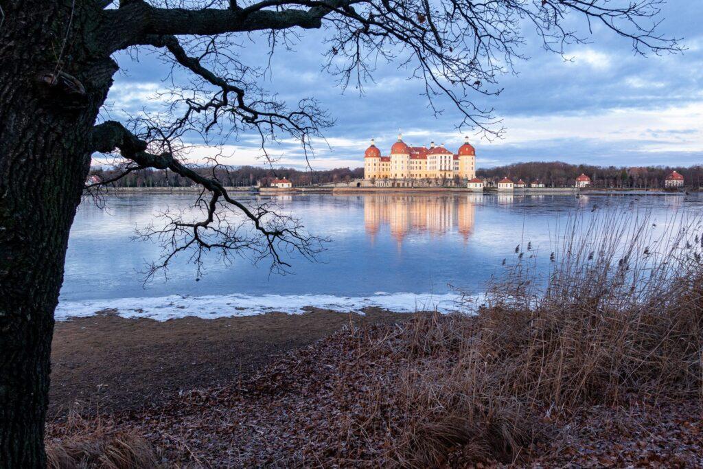 Winterliche Landschaft mit Schloss und zugefrorenem See in Sachsen – symbolisches Beitragsbild zu heizölpreise sachsen